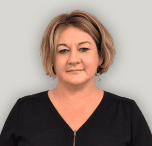 Andrea Portrait of a woman with short blonde hair wearing a black top, facing the camera with a neutral expression.