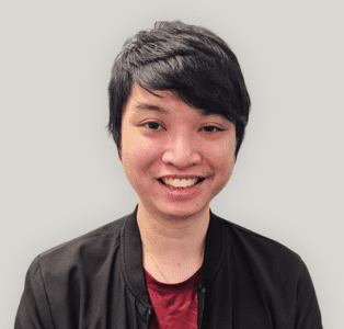 Leroy Huang Portrait of a smiling person with short black hair, wearing a dark jacket over a red shirt.